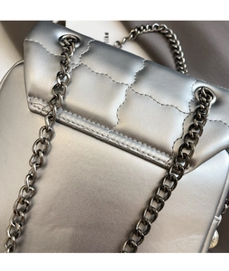 Detail of silver quilted handbag with high-quality metal chain strap and stitching