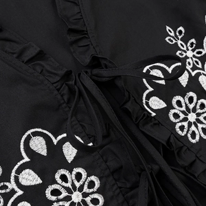 Women's black shirt with white floral embroidery, ruffle collar and front lace-up details