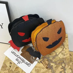Detail of sequined orange and matte black pumpkin shaped crossbody bags with bat charms