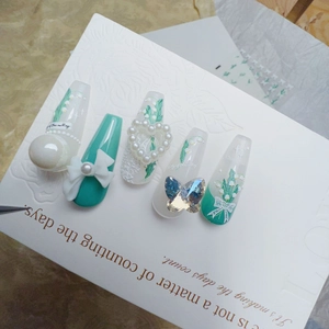 Detailed view of floral nail stickers with pearls, blue ribbon, and tulip relief art