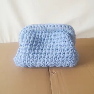 Detailed view of light blue hand-woven crochet clutch bag with thick soft texture