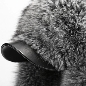 Detail of gray faux fur trim and black leather brim on a warm winter trapper hat