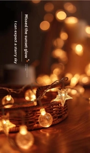 Detail of warm yellow solar star and ball string lights in a rustic woven basket