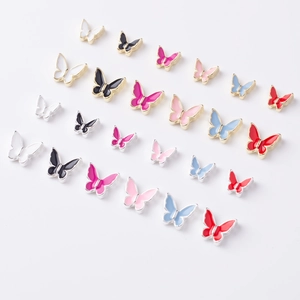 Detailed close-up of colorful alloy butterfly nail charms in various vibrant enamel colors