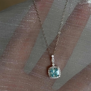 Elegant halo necklace with square blue gemstone pendant and shimmering silver chain