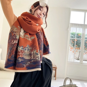 Close-up of orange cashmere scarf with Chinese landscape art and elegant tassel trim