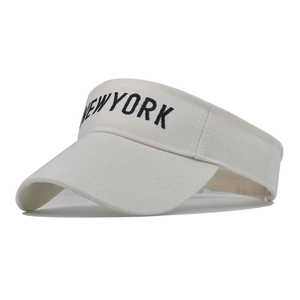Detail view of New York embroidery on a beige sun visor cap with premium cotton texture