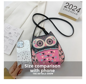 Size comparison between cartoon owl crossbody bag and a smartphone for scale
