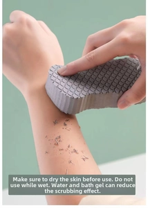 Detail showing deep gray 3D bath sponge with fish scale texture used on dry arm skin
