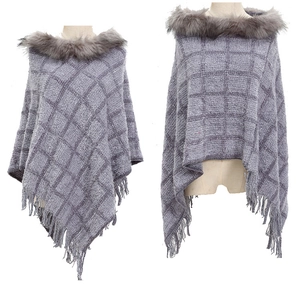 Detail shot of grey plaid knit poncho featuring faux fur collar and fringe hemline