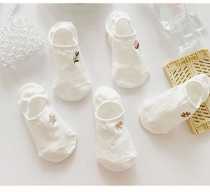 Detail of five pairs white cotton liner socks with delicate floral and bow embroidery