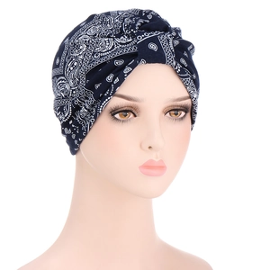 Detailed close-up of dark blue paisley turban cap on a female model head form