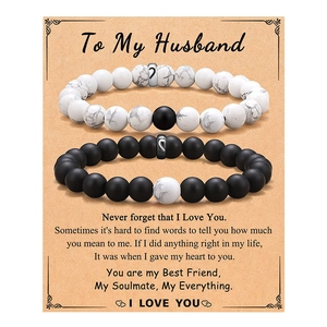 Close-up of couple bracelets with heart pendants on a romantic To My Husband card