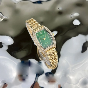 Close-up of luxury tonneau quartz watch with emerald green dial and rhinestone bezel