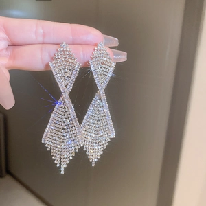 Macro shot of silver tassel earrings with sparkling rhinestones in a geometric design