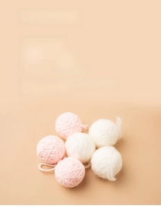 Close-up of fluffy pink and white yarn ball decorations for DIY Christmas crafts