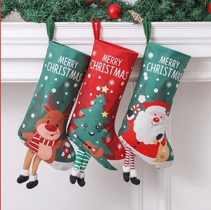 Three festive Christmas stockings with reindeer and Santa designs hanging on a fireplace