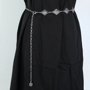 Detail of silver metal chain belt with vintage diamond links and flower charm pendant