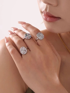 Close-up of stacked silver rings with moon star motifs and multi-colored zircon stones