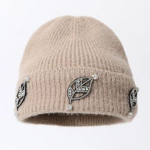 Macro detail of beige knitted beanie featuring sparkling leaf rhinestone decorations