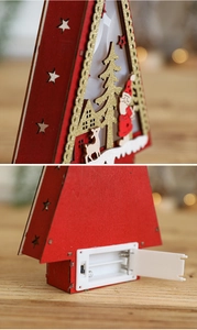 Detail of red wooden Christmas tree ornament with laser-cut patterns and warm LED lights