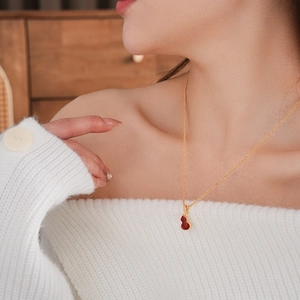 Close-up of gold-plated double-sided gourd pendant necklace on female neck