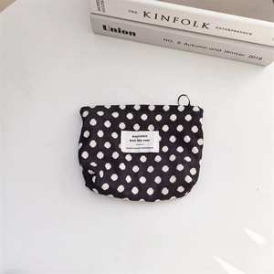 Close-up of a vintage corduroy storage bag with black and white polka dot patterns