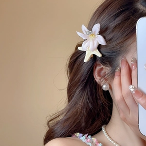 Close-up of pink fabric flower hair clip with starfish accent and small rhinestones