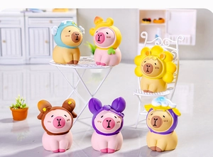 Close-up of miniature Capybara figurines dressed in animal and fruit costumes on a desk