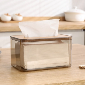 Nordic grey transparent tissue box with wooden lid on a light wood surface