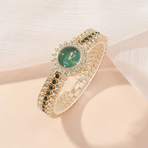 Detailed macro view of gold-plated quartz watch with green crystals and sparkling dial