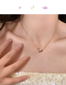 Détail du collier pendentif lettre D en or rose avec cristaux sur un cou de femme