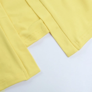 Gros plan détaillé sur la couture double du tissu en maille côtelée jaune du vêtement