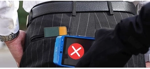 Slim RFID blocking wallet in green and orange leather tucked in a men's back pocket