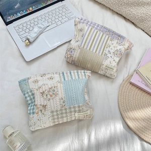 Flat lay of floral quilted makeup bags with stripe patchwork and woven brand label