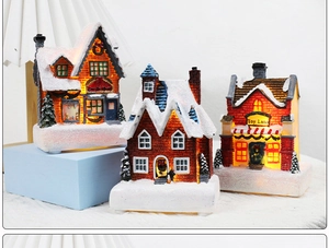 Detailed view of three glowing resin Christmas house models with warm lights and snowy textures