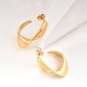 Minimalist twisted gold stainless steel hoop earrings with polished metal texture