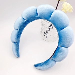 Macro detail of the light blue velvet headband featuring a soft padded pleated texture