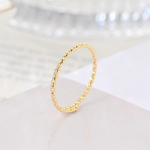 Macro shot of minimalist gold twisted titanium steel ring with textured surface finish