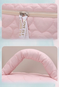 Detail of pink quilted makeup bag with heart patterns and soft padded handle