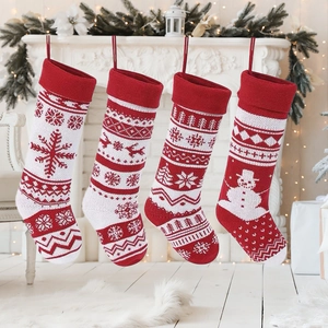 Set of four red and white knitted Christmas stockings with snowflake and reindeer patterns