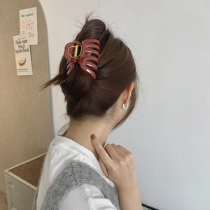 Model wearing a large dark red resin hair claw clip for an elegant and secure hairstyle