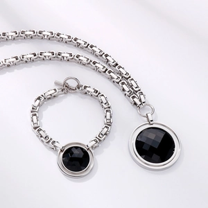 Detailed macro view of the silver chain necklace and bracelet set with black round stones
