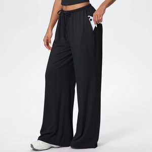 Detail view of deep side pockets on black wide-leg drawstring pants with a phone inside