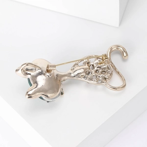 Detailed back view of gold cat brooch showing secure pin clasp and green crystal