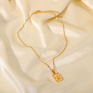 Close-up of 18K gold plated rectangular pendant with angel relief and pavé zircons