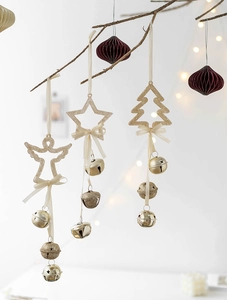 Detail of glittery gold angel and star bell pendants hanging on a festive Christmas branch