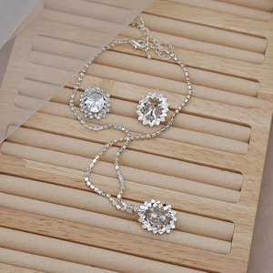 Detailed close-up of zircon jewelry set with oval stones on a wooden velvet display