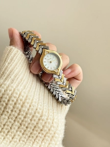 Detail of Scottie watch featuring bicolor V-link band and iridescent pearl dial