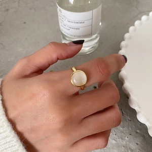 Minimalist S925 silver ring in gold with round cat eye stone shown on a hand
